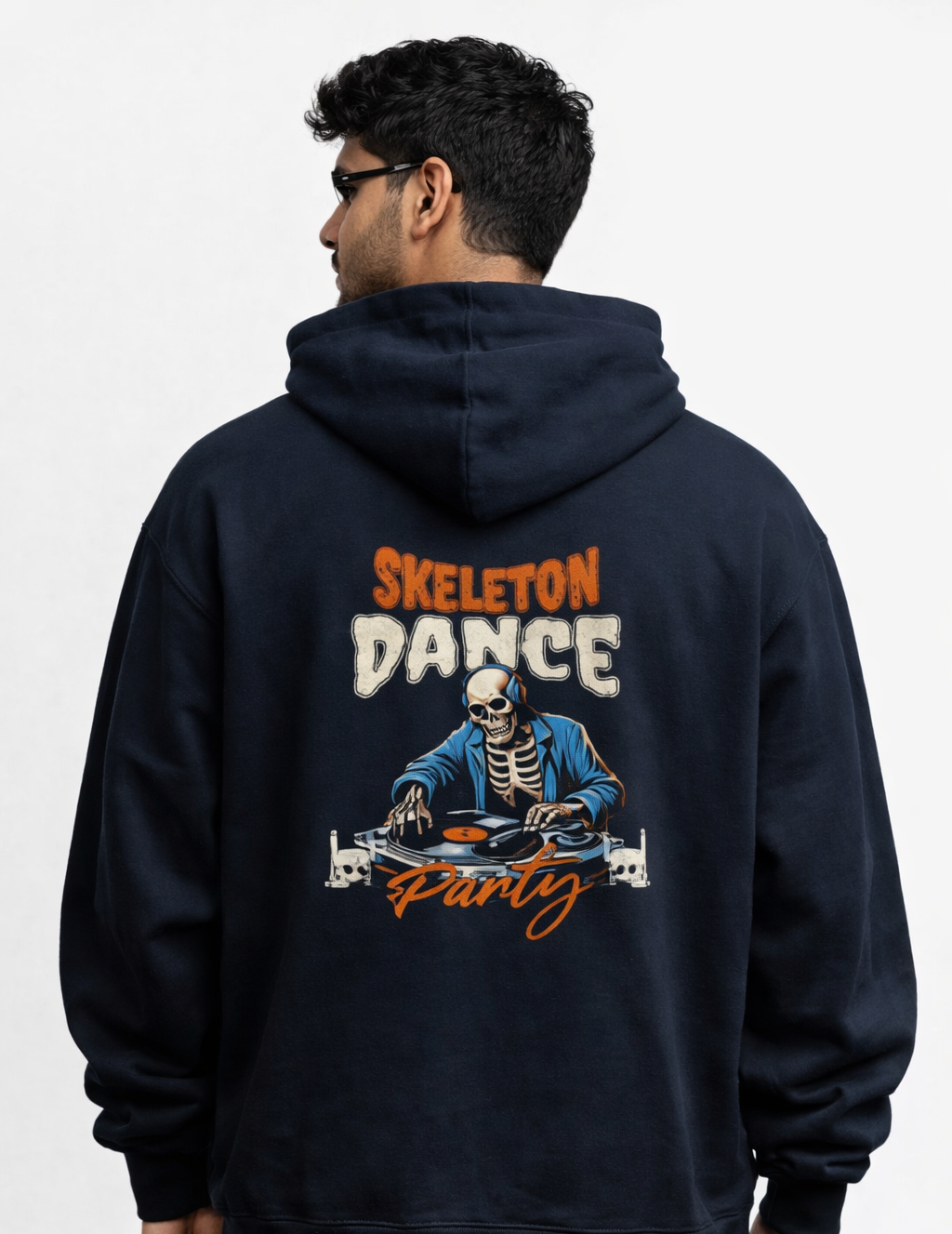 Person wearing a navy hoodie with a skeleton dancing design on the back against a white background