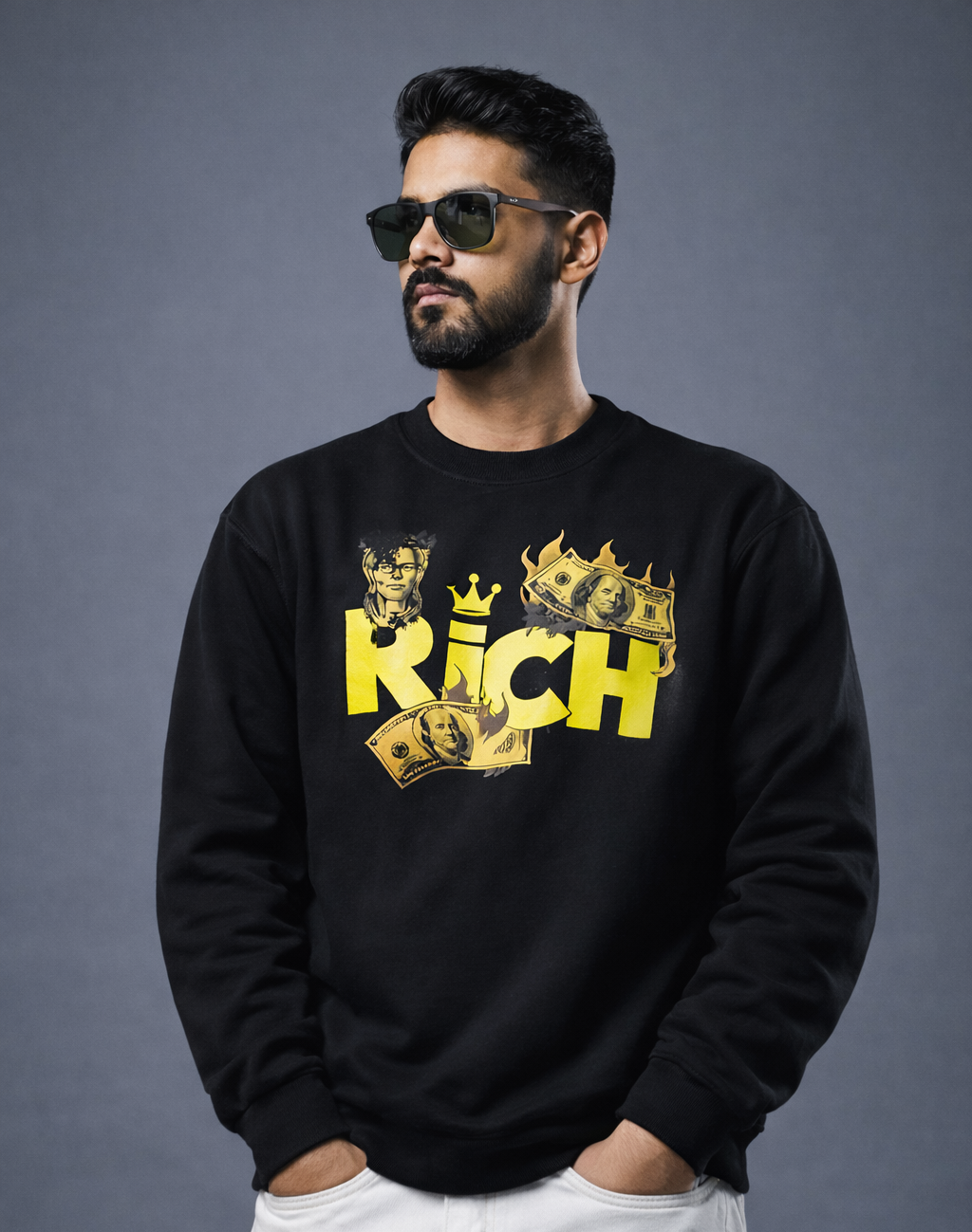 Man wearing a black sweatshirt with 'RICH' and card design, standing against a gray background
